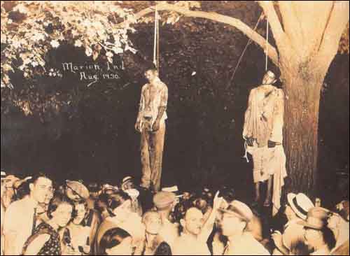 1930년에 백인들의 린치로 사망한 ‘흑인’ 토마스 쉽（Thomas Shipp）과 아브람 스미스（Abram Smith）. 나무 밑에는 잘 차려입고 모자까지 챙겨 쓴 ‘백인’ 군중들이 의식에 참여하고 있다. (혐주의)이상한 열매 (혐주의) 이상한 열매